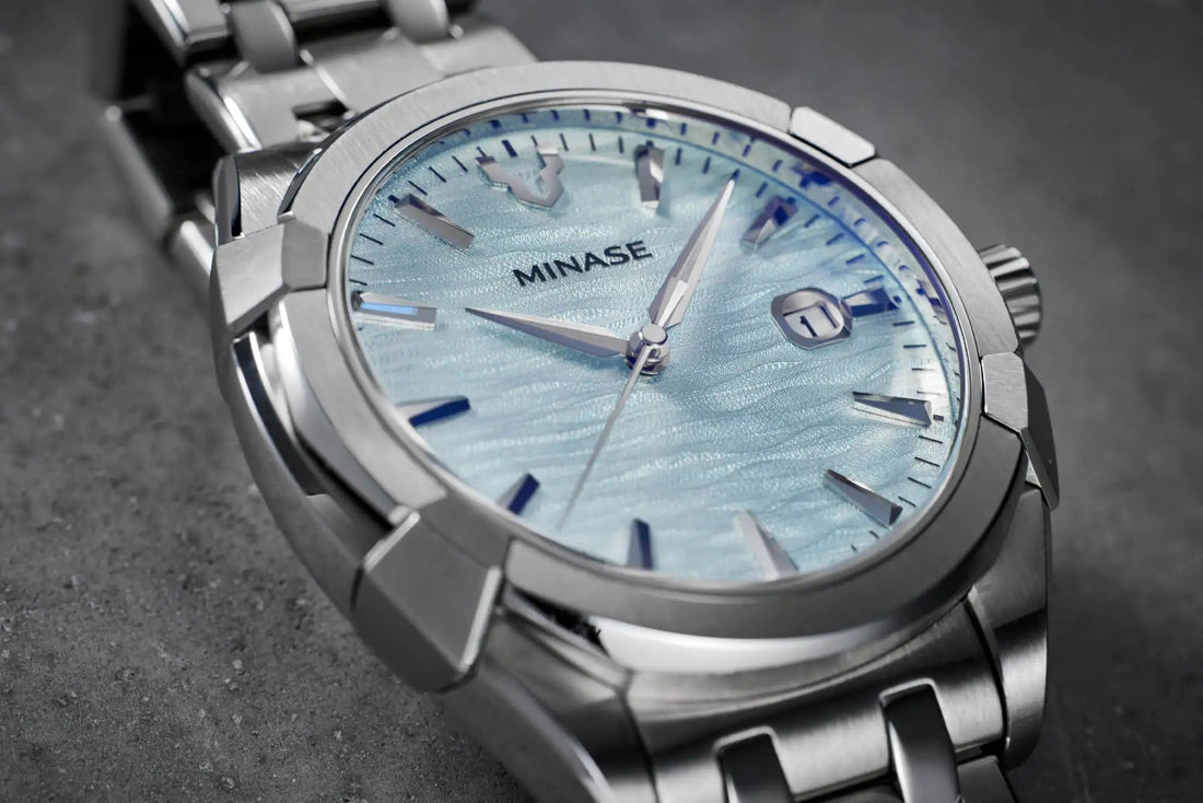 MINASE URUGA in stainless steel — mirror-polished bezel facets and brushed surfaces catching the light, the result of Sallaz (zaratsu) hand polishing